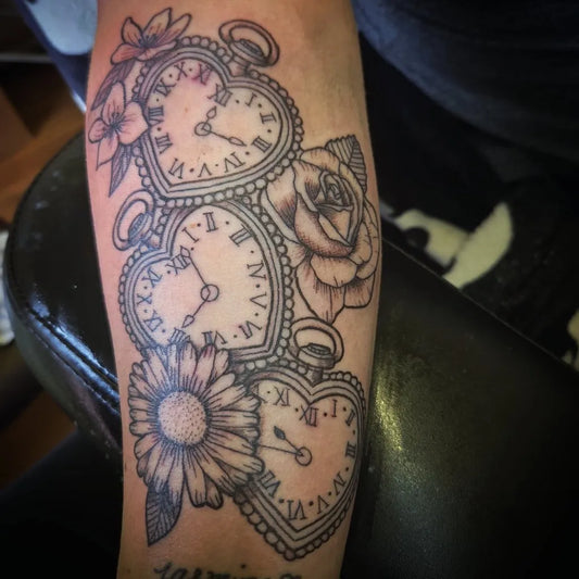 Medium Black and Grey Heart Clocks and Flowers Tattoo on Women Arm by @v_fogarty