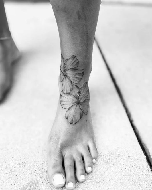 Medium Black and Grey Hibiscus Flowers Tattoo on Women Foot by @apolvitattoos