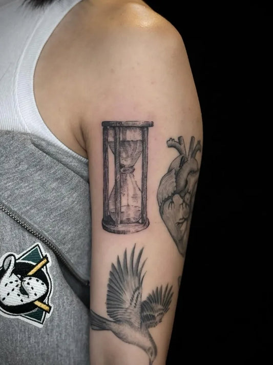 Medium Black and Grey Hourglass Heart Bird Tattoo on Women Arm by @ms_aleen