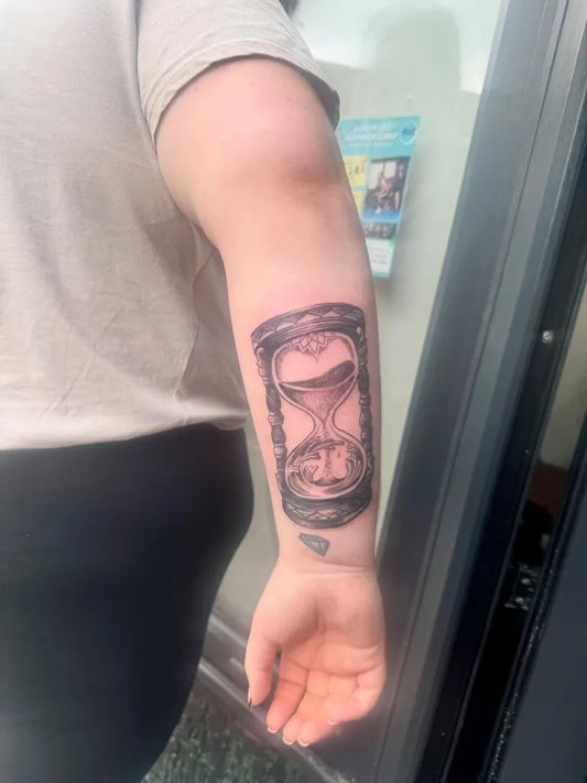 Medium Black and Grey Hourglass Tattoo on Women Forearm by @black.pearltattooparlour