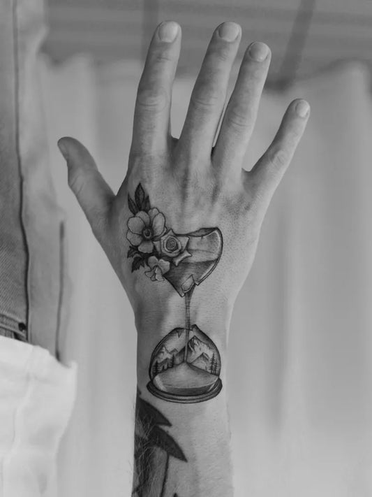 Medium Black and Grey Hourglass with Flower Tattoo on Men Wrist by @quindaytattoos