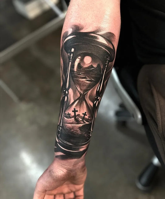 Medium Black and Grey Hourglass with Landscape and Tombstones Tattoo on Men Arm by @jeff_tattooer