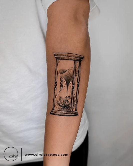 Medium Black and Grey Hourglass with Lotus Tattoo on Men Arm by @circletattoodadar