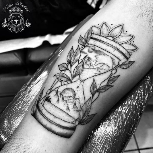 Medium Black and Grey Hourglass with Mountain and Foliage Tattoo on Men Arm by @tattoo_addiiict