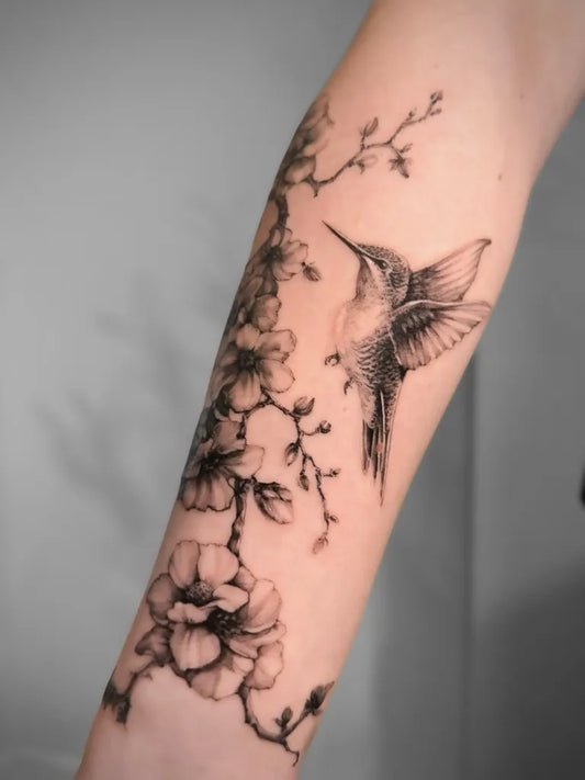 Medium Black and Grey Hummingbird and Cherry Blossom on Women Arm Tattoo by @jaded.tattoo.studios