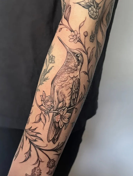 Medium Black and Grey Hummingbird and Flowers on Women Arm Tattoo by @libbynixtattoo