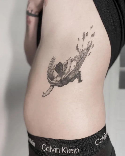 Medium Black and Grey Icarus with Falling Wings on Men Rib Tattoo by @_binkk_