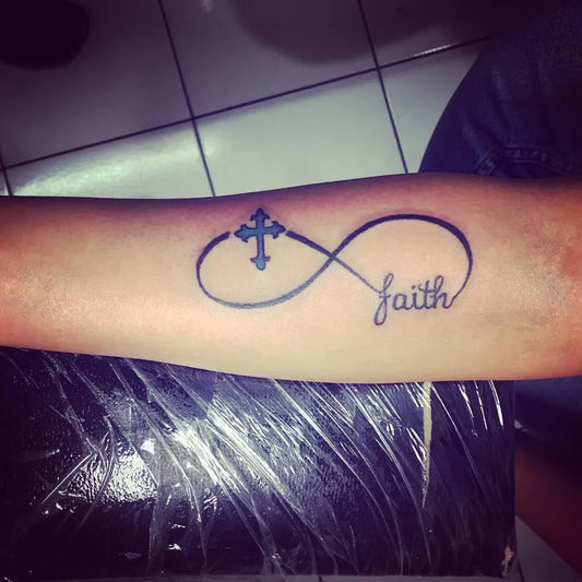 Medium Black and Grey Infinity Cross Faith Tattoo on Women Forearm by @7fukujintattoo