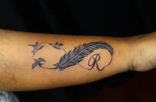 Medium Black and Grey Infinity Feather Birds Tattoo on Men Wrist by @nikhil_thetattooart_