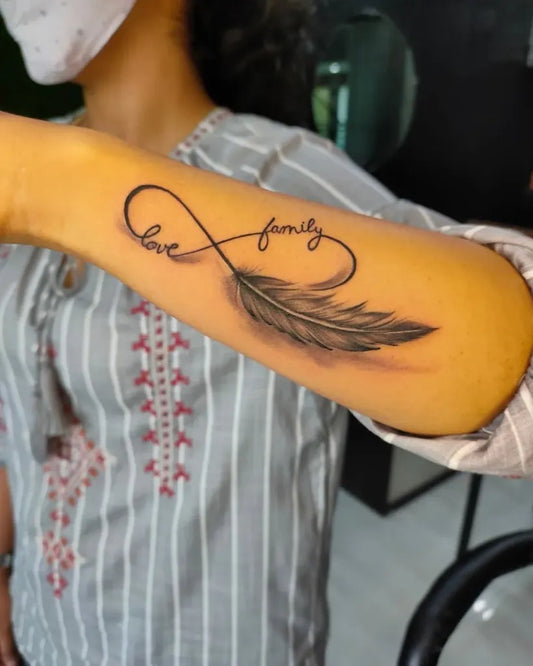 Medium Black and Grey Infinity Feather Love Family Tattoo on Women Forearm by @_soul_tattoo_studio_