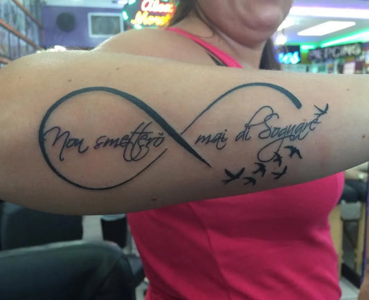 Medium Black and Grey Infinity Symbol with Birds and Italian Text Tattoo on Women Arm by @tattoobluesftl