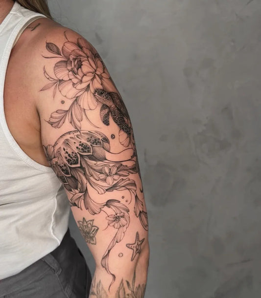 Medium Black and Grey Jellyfish Koi and Peonies Tattoo on Women Arm by @gabriela.tattoo