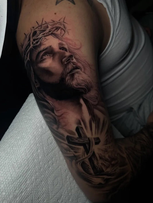 Medium Black and Grey Jesus with Crown of Thorns and Cross Tattoo on Men Arm by @gabriel.tattoooart
