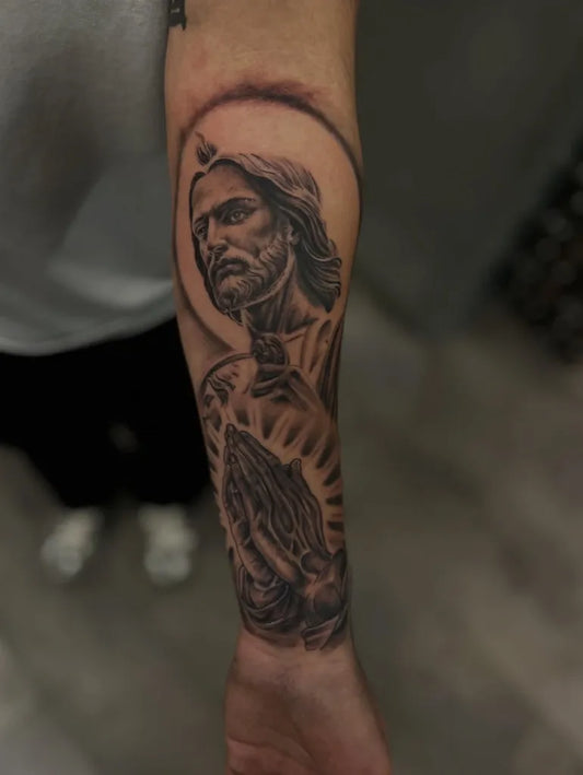Medium Black and Grey Jesus with Praying Hands Tattoo on Men Arm by @el_valle_az_tattoos