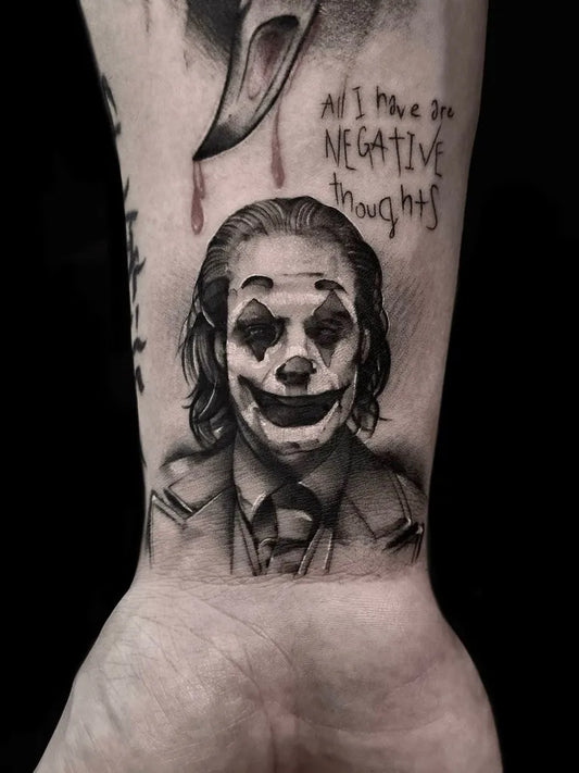 Medium Black and Grey Joker Portrait with Negative Thoughts Text on Men Wrist Tattoo by @gusoe_ttt