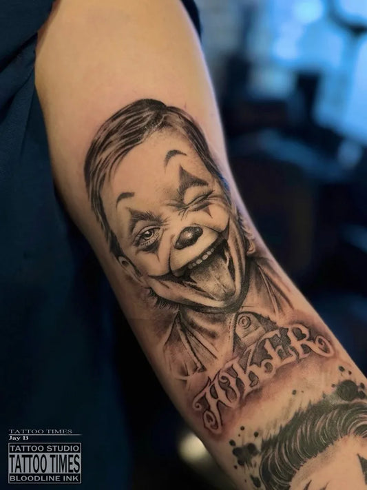 Medium Black and Grey Joker with text on Men Arm Tattoo by @tattoo.times