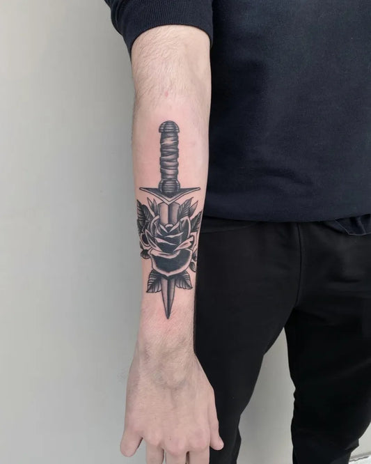 Medium Black and Grey Knife and Rose Tattoo on Men Arm by @unicorn.tattoo