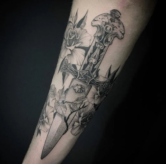 Medium Black and Grey Knife and Roses Tattoo on Women Arm by @ninetyninetattoo