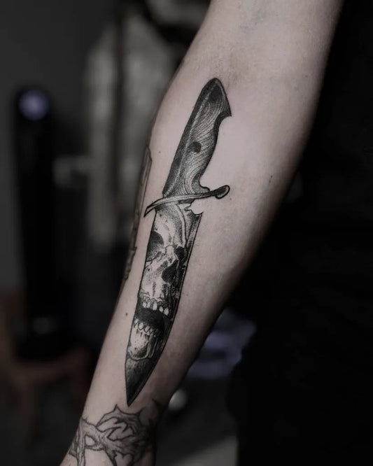 Medium Black and Grey Knife and Skull Tattoo on Women Arm by @nefor.ink