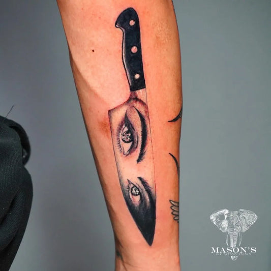 Medium Black and Grey Knife with Eye Tattoo on Men Arm by @masonsinkstudio_bali