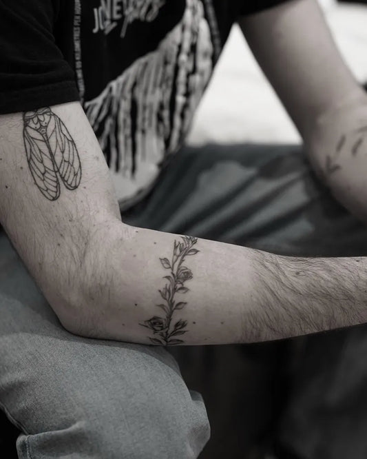 Medium Black and Grey Laurel Wreath and Moth Tattoo on Men Arm by @tattoobysoso