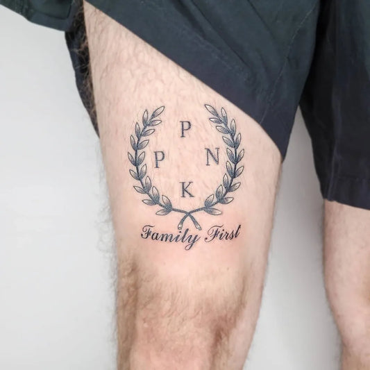 Medium Black and Grey Laurel Wreath with Initials and Family First Text Tattoo on Men Thigh by @dusseldorftattoo_zero2