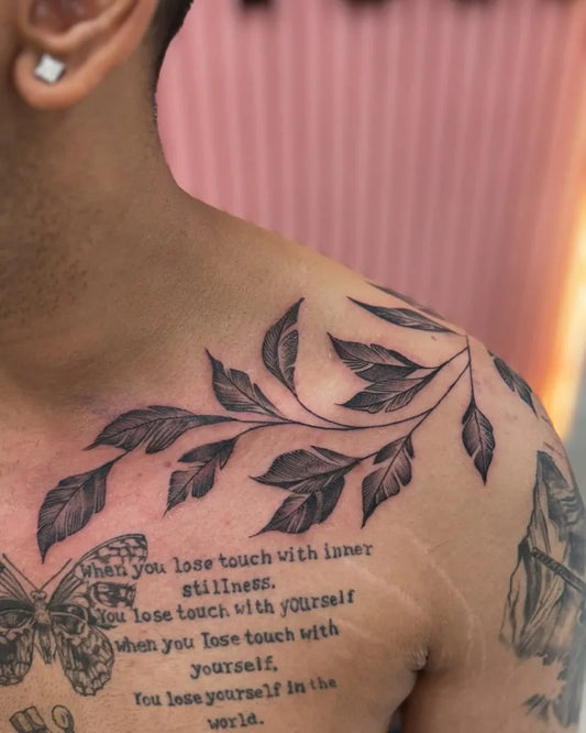 Medium Black and Grey Leaf Branch with Quote Tattoo on Men Shoulder by @delhi_ink_tattooz