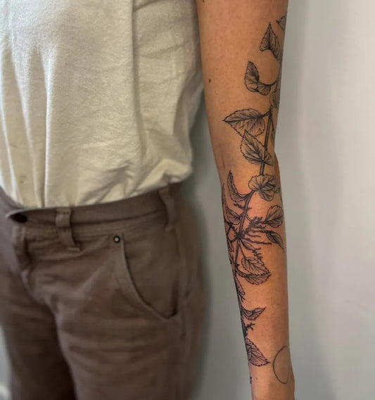 Medium Black and Grey Leaves and Vines Nature Tattoo on Women Arm by @seed.eternal