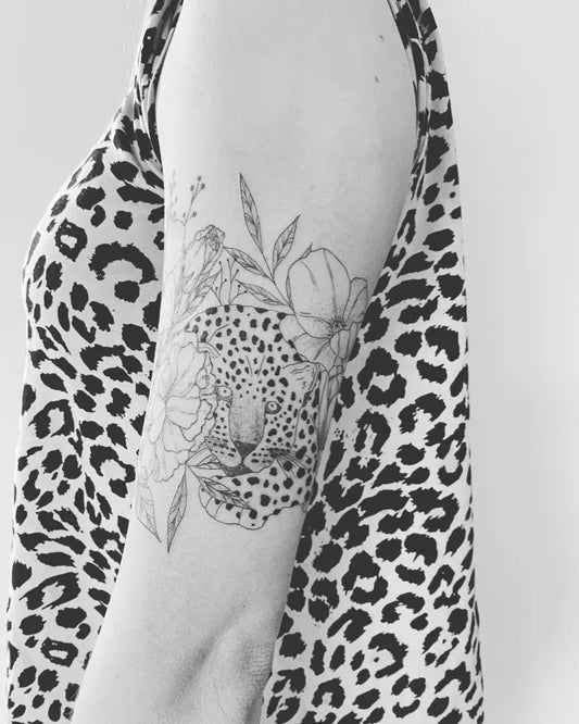 Medium Black and Grey Leopard and Flowers Tattoo on Women Bicep by @saltandinknz