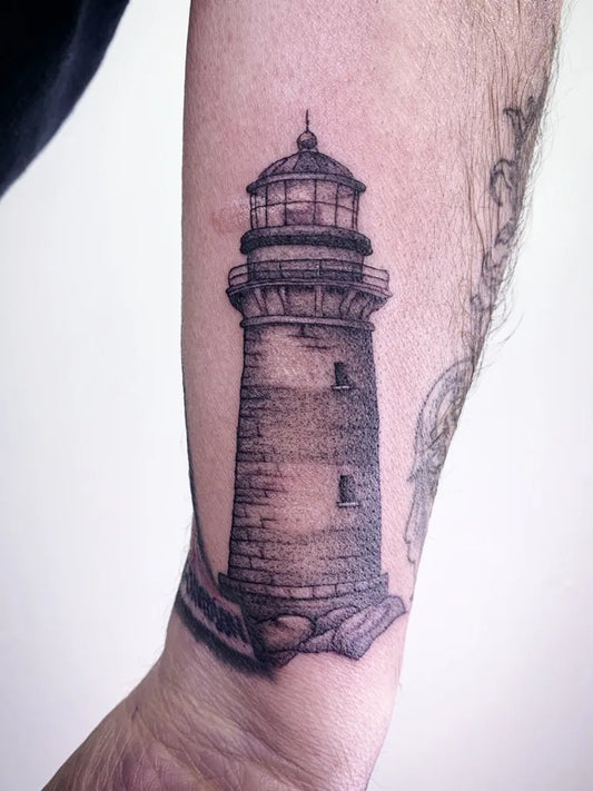 Medium Black and Grey Lighthouse Tattoo on Men Arm by @odyssey.tattoo