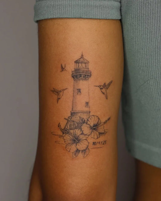 Medium Black and Grey Lighthouse with Hummingbirds and Hibiscus Tattoo on Women Arm by @inkedcarolina