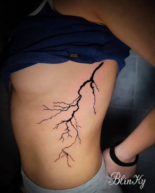 Medium Black and Grey Lightning Bolt Tattoo on Women Ribs by @blinkytattoo