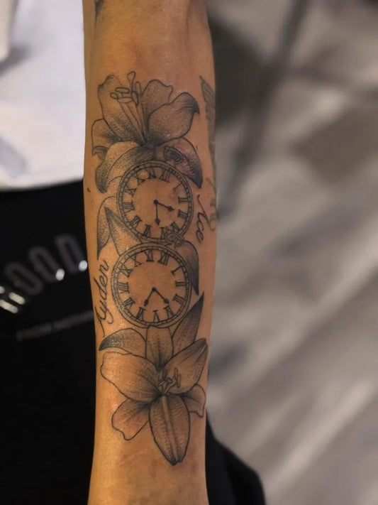 Medium Black and Grey Lily and Clock Tattoo on Women Arm by @the_ink_vibez_