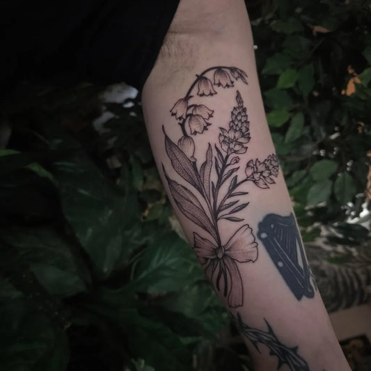 Medium Black and Grey Lily of the Valley Bouquet with Bow and Shamrock on Men Arm Tattoo by @alexandraathenstattoo