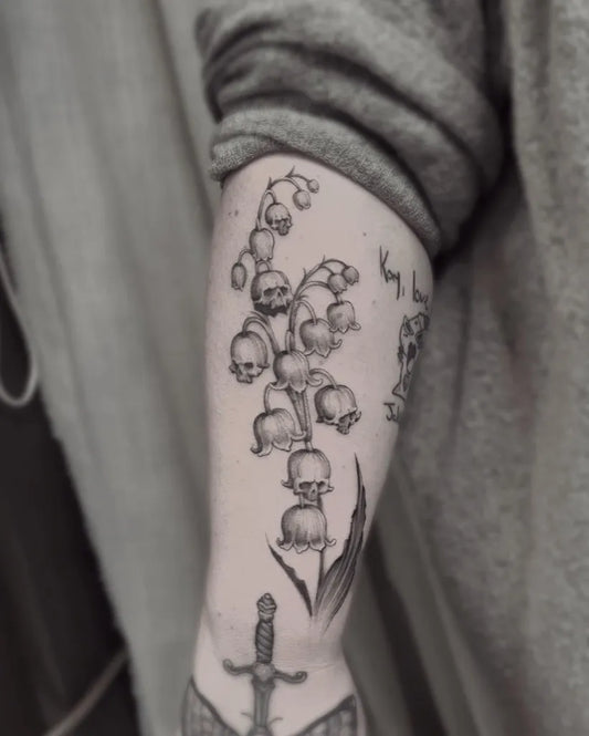 Medium Black and Grey Lily of the Valley with Skulls and Dagger on Women Arm Tattoo by @gruyay