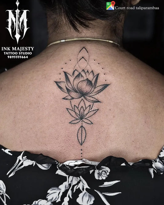 Medium Black and Grey Lotus Flowers on Women Back Tattoo by @tattoo_ink_majesty_taliparamba