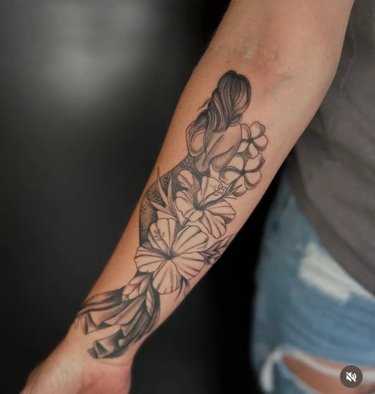 Medium Black and Grey Mermaid with Flowers Tattoo on Women Arm by @revelationtattooco