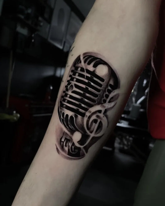 Medium Black and Grey Microphone and Treble Clef Music Tattoo on Women Arm by @connor_osbornetattoos