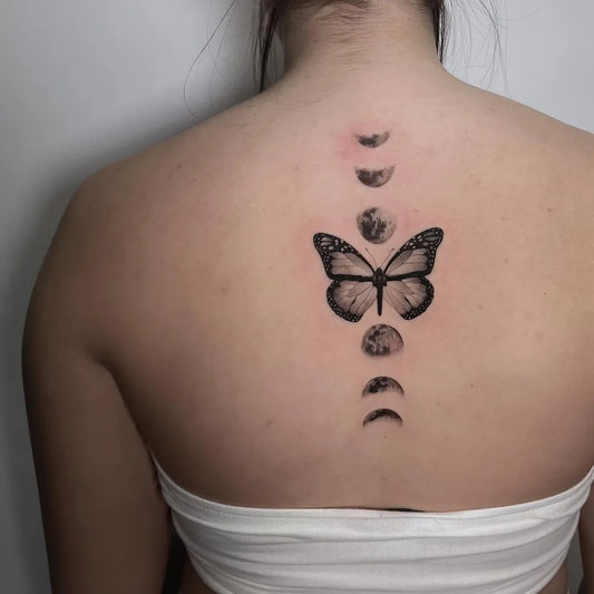Medium Black and Grey Moon Phases Butterfly Tattoo on Women Back by @victoria.tattoos