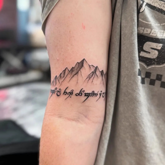 Medium Black and Grey Mountain and Tengwar Script Tattoo on Men Arm by @otqt_dailytatts