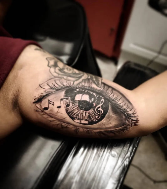 Medium Black and Grey Musical Eye Tattoo on Men Bicep by @tiagotargacampos