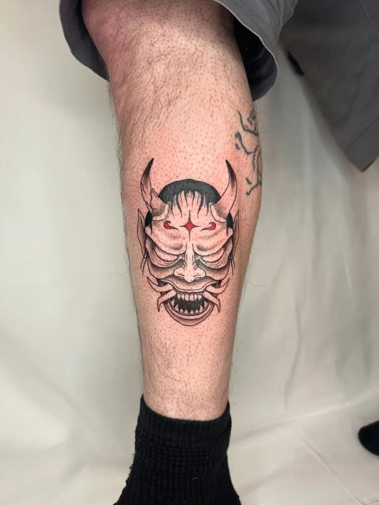 Medium Black and Grey Oni Mask with Horns and Red Eyes on Men Leg Tattoo by @violetvixenink