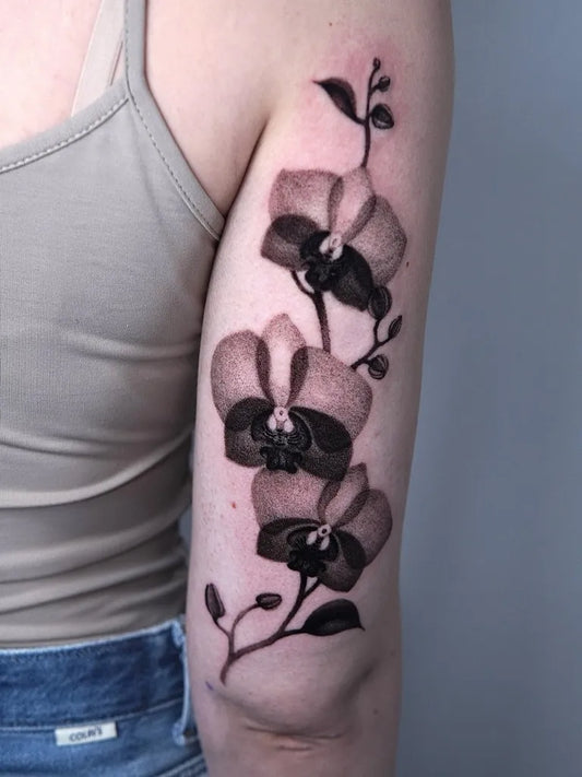Medium Black and Grey Orchid Flowers Tattoo on Women Arm by @m.flueras