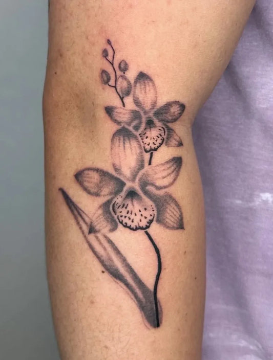 Medium Black and Grey Orchid Flowers Tattoo on Women Arm by @sensitive.chaos.tattoo