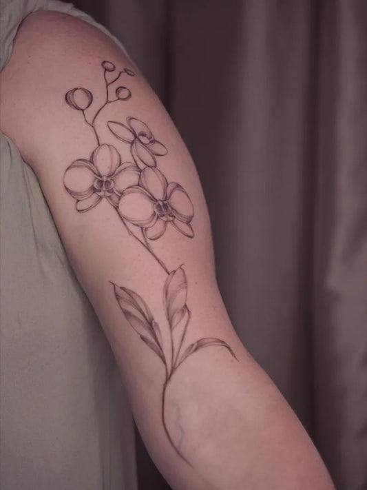 Medium Black and Grey Orchid Tattoo on Women Arm by @anjaodeb.art