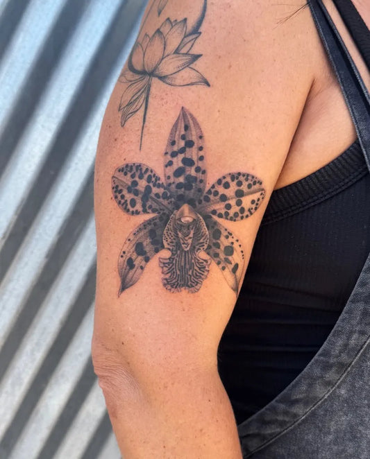 Medium Black and Grey Orchid Tattoo on Women Arm by @siickseed