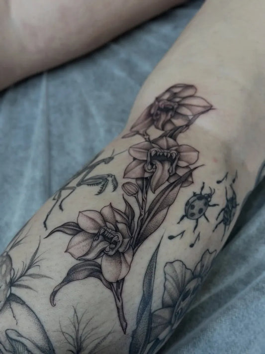 Medium Black and Grey Orchid and Ladybug Tattoo on Women Arm by @samantha.tattoo