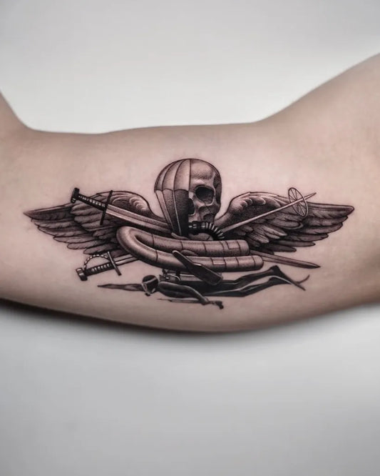 Medium Black and Grey Parachute Skull Wings Military Tattoo on Men Arm by @miatattoo