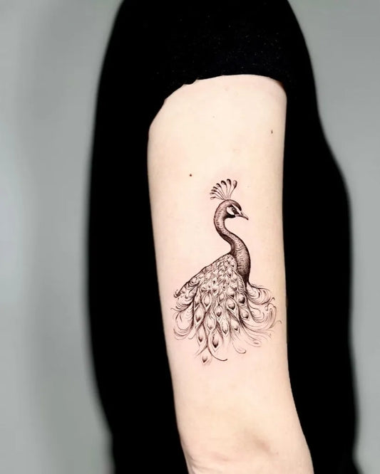 Medium Black and Grey Peacock Tattoo on Women Arm by @cela.ink