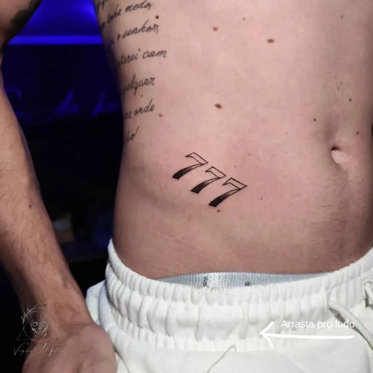 Medium Black and Grey Portuguese Text and 777 Tattoo on Men Side by @virgilio.arttattoo